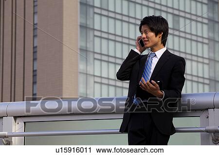 Businessman on mobile phone and using digital tablet outdoors View Large Photo Image Stock Image - Businessman on mobile phone and using digital tablet outdoors. Fotosearch
