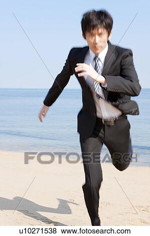 Businessman running at beach View Large Photo Image Stock Photo - Businessman running at beach. Fotosearch