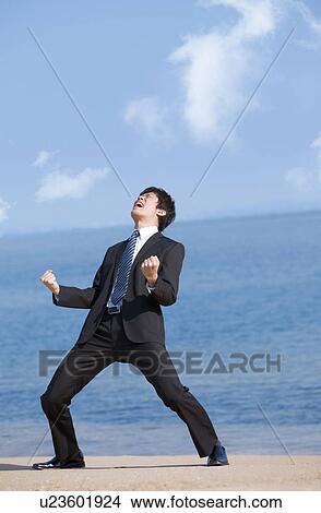 Picture - Businessman shouting at a beach. Fotosearch