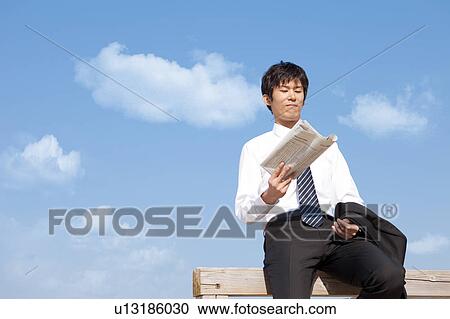 Businessman sitting on fence reading newspaper View Large Photo Image Stock Image - Businessman sitting on fence reading newspaper. Fotosearch