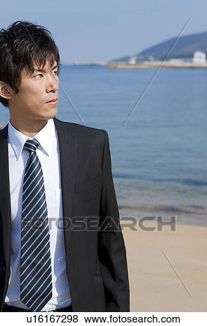 Businessman standing on the beach View Large Photo Image Stock Photo - Businessman standing on the beach. Fotosearch