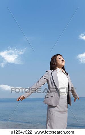 Stock Image - Businesswoman stretching arms. Fotosearch