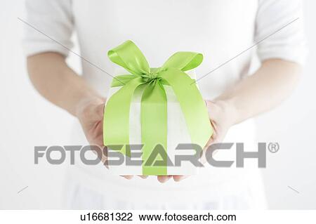 Stock Image - Close Up of Young Woman Holding Gift. Fotosearch