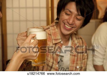 Couple toasting with beer View Large Photo Image Stock Photograph - Couple toasting with beer. Fotosearch