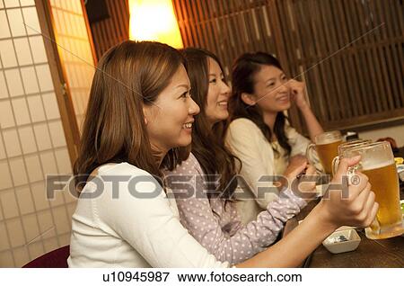 Friends holding glasses of beer View Large Photo Image Stock Photo - Friends holding glasses of beer. Fotosearch