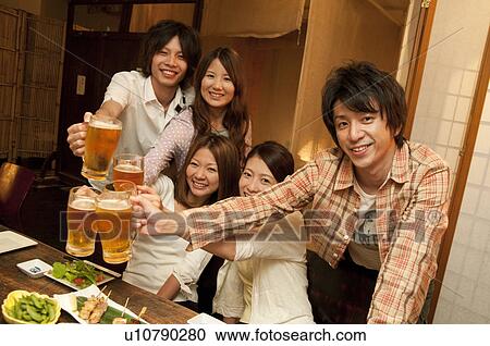 Friends toasting at a bar View Large Photo Image Stock Image - Friends toasting at a bar. Fotosearch