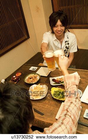 Friends toasting at a bar View Large Photo Image Stock Image - Friends toasting at a bar. Fotosearch