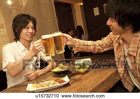 Friends toasting at a bar View Large Photo Image Stock Image - Friends toasting at a bar. Fotosearch
