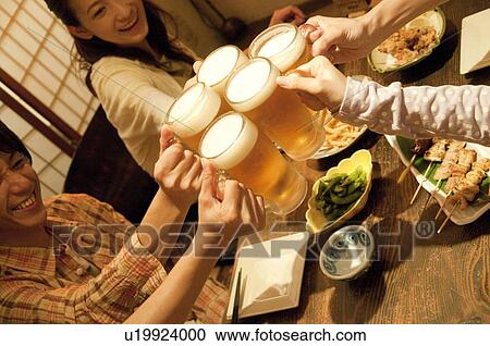 Friends toasting at a bar View Large Photo Image Stock Image - Friends toasting at a bar. Fotosearch