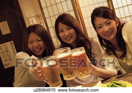 Friends toasting at a bar View Large Photo Image Stock Image - Friends toasting at a bar. Fotosearch