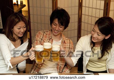 Stock Photo - Friends toasting at a bar. Fotosearch