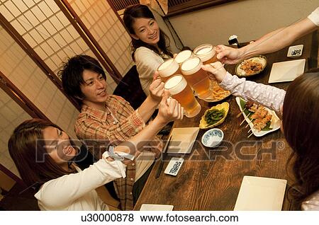 Friends toasting at a bar View Large Photo Image Stock Photo - Friends toasting at a bar. Fotosearch