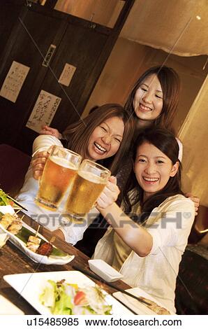 Stock Photography - Friends toasting at a bar. Fotosearch