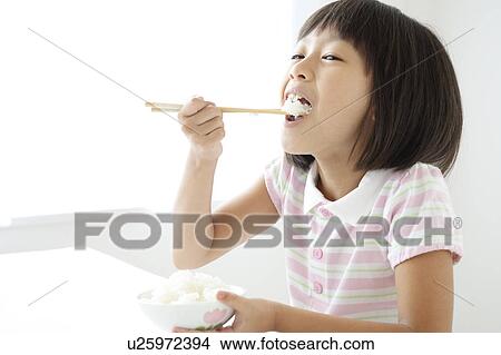 Picture - Girl Eating Rice. Fotosearch
