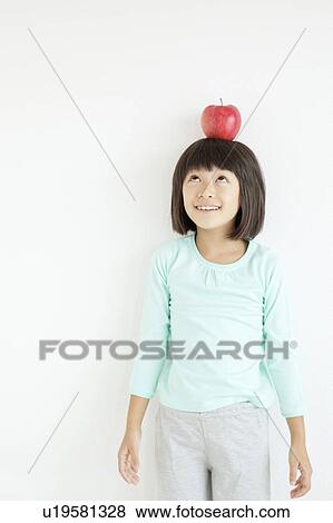 Stock Photo - Girl with Apple On Her Head. Fotosearch