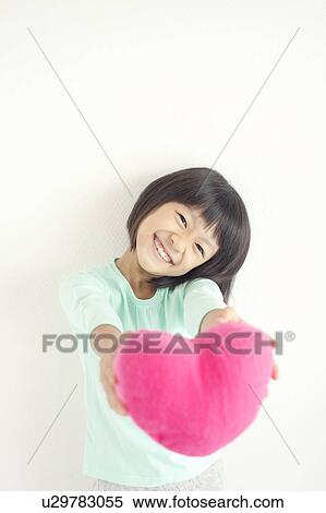Stock Photography - Girl with Heart Shaped Cushion. Fotosearch