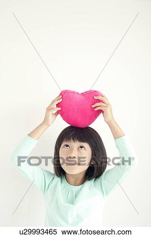 Stock Photography - Girl with Heart Shaped Cushion. Fotosearch