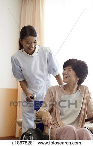 Stock Image - Healthcare Worker and Patient in Wheelchair. Fotosearch