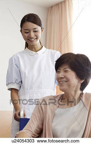 Stock Image - Healthcare Worker and Patient in Wheelchair. Fotosearch