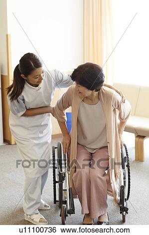 Stock Photograph - Healthcare Worker and Patient in Wheelchair. Fotosearch