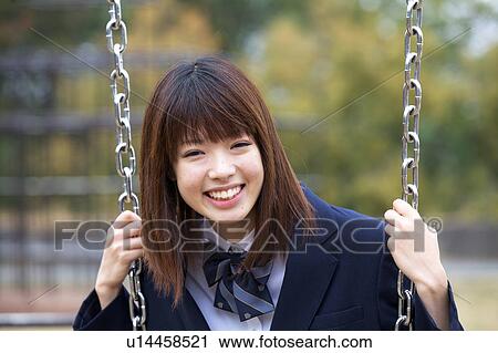 Stock Image - High school girl on a swing. Fotosearch
