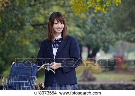 High school girl pushing bicycle View Large Photo Image Picture - High school girl pushing bicycle. Fotosearch