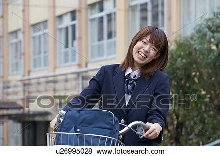 Stock Photo - High school girl pushing bicycle. Fotosearch