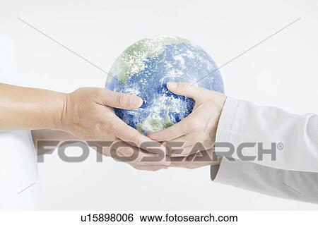 Stock Photograph - Mature man and woman holding globe. Fotosearch