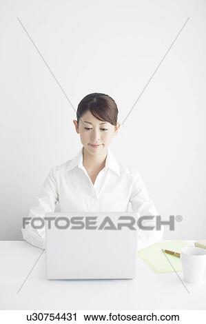 Stock Image - Mid Adult Businesswoman Working. Fotosearch