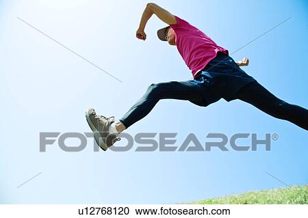 Stock Image - Mid Adult Man Jumping. Fotosearch