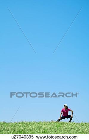 Stock Photography - Mid Adult Man Stretching Under Blue Sky. Fotosearch