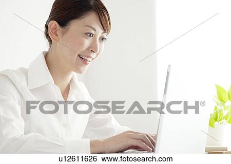 Stock Photograph - Mid Adult Woman Using Laptop. Fotosearch