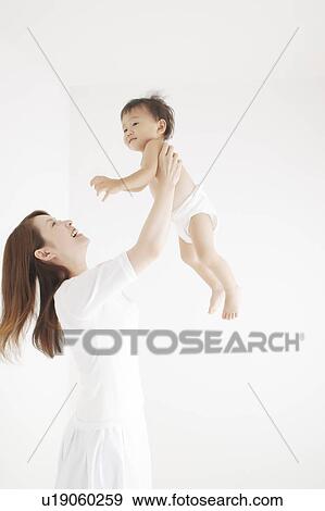 Stock Photo - Mother Holding Baby Boy Aloft. Fotosearch