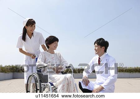 Picture - Nurse and Doctor with Female Patient in Wheelchair. Fotosearch
