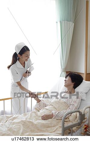 Stock Image - Nurse Caring For Female Patient. Fotosearch