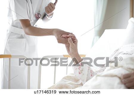 Stock Photo - Nurse Holding Patient's Hand. Fotosearch