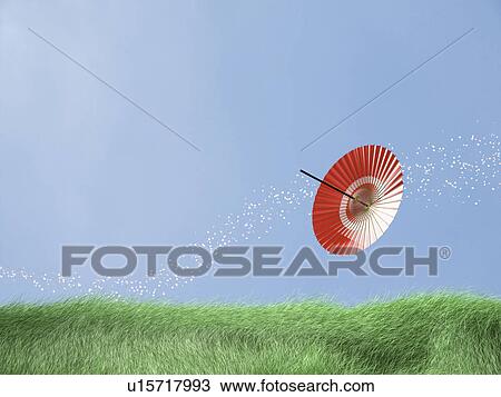 Stock Image - Paper umbrella in a field. Fotosearch