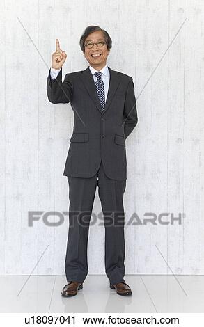 Stock Image - Portrait of senior businessman with number one sign. Fotosearch