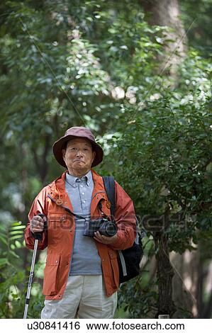 Stock Photograph - Portrait of senior man with camera. Fotosearch