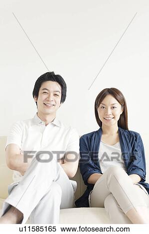 Portrait of young couple sitting of sofa View Large Photo Image Stock Photography - Portrait of young couple sitting of sofa. Fotosearch