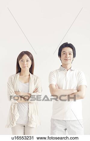Stock Image - Portrait of young couple with arms crossed. Fotosearch