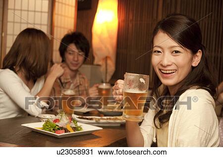 Portrait of young woman holding a glass of beer View Large Photo Image Stock Image - Portrait of young woman holding a glass of beer. Fotosearch