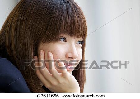 Stock Photograph - Profile of high school girl with hand on chin. Fotosearch