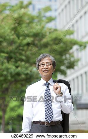 Stock Photo - Senior businessman holding jacket. Fotosearch