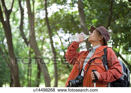 Stock Photo - Senior man drinking bottled water. Fotosearch