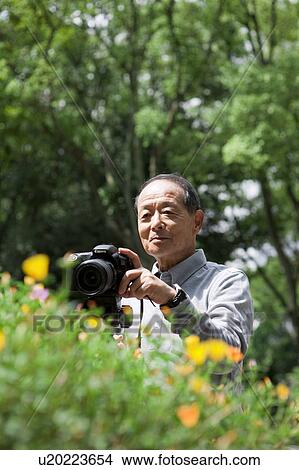 Picture - Senior man with camera. Fotosearch