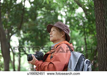 Stock Image - Senior man with camera. Fotosearch