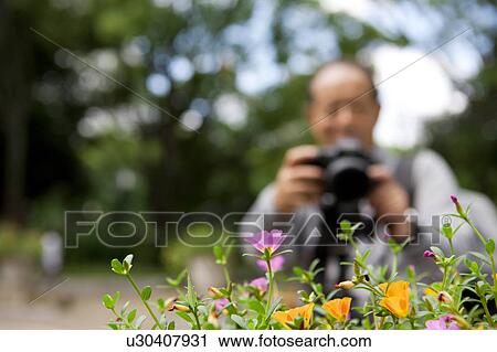 Stock Image - Senior man with camera. Fotosearch