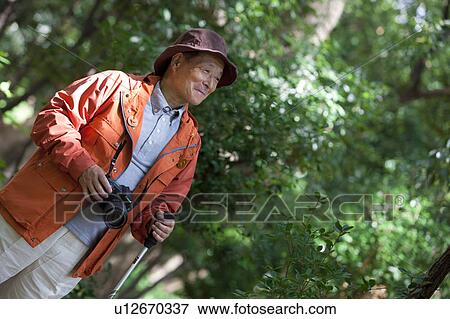 Stock Photo - Senior man with camera. Fotosearch