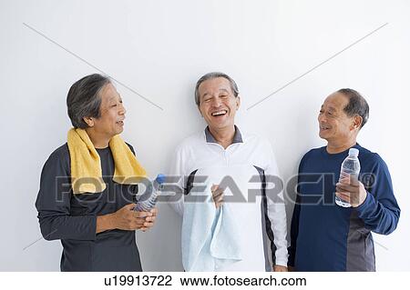 Stock Image - Senior men standing and talking. Fotosearch